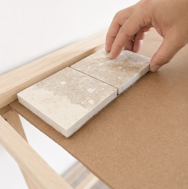 Hands arranging mycelium composite tiles